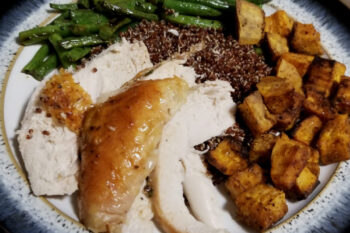 A plate of roast chicken, sweet potatoes, quinoa, and green beans.