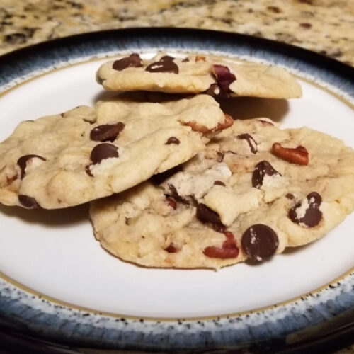 Three chocolate chip and pecan cookies stacked on each other