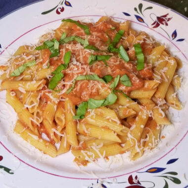 A close up of pasta with tomato cream sauce.
