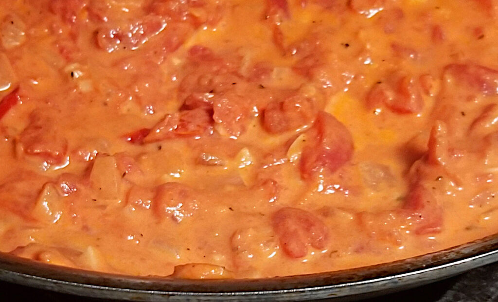 creamy sun dried tomato sauce simmering in a pan. 