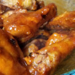 A close up of hot honey bourbon coated chicken wings.