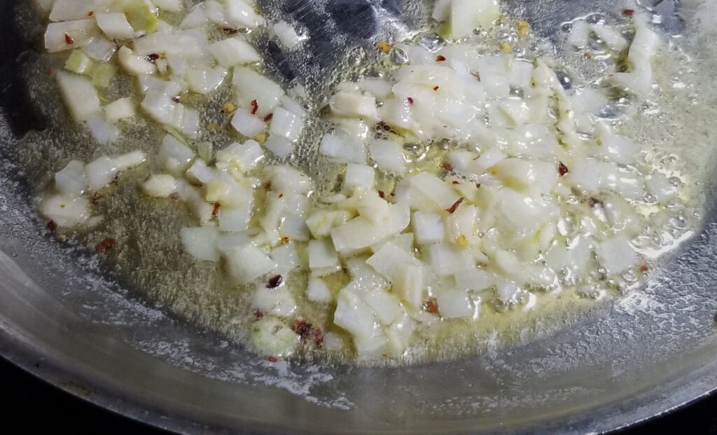 Onions and red pepper flakes cooking in butter.
