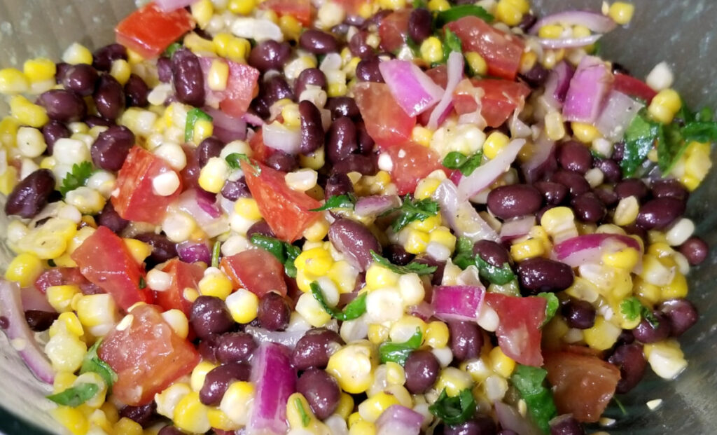 Mixed bean and corn salad in a glass bowl.