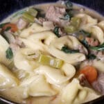 A close up of creamy sausage and tortellini soup