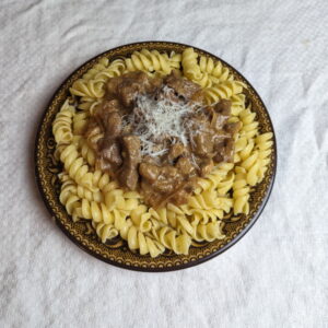 Beef stroganoff served over buttered noodles with shredded parmesan.