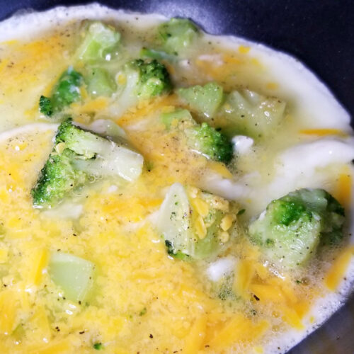 A close up of the egg white omelet in a pan, partway cooked.