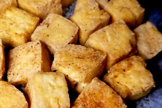 A close up of air fryer tofu on a blue plate.