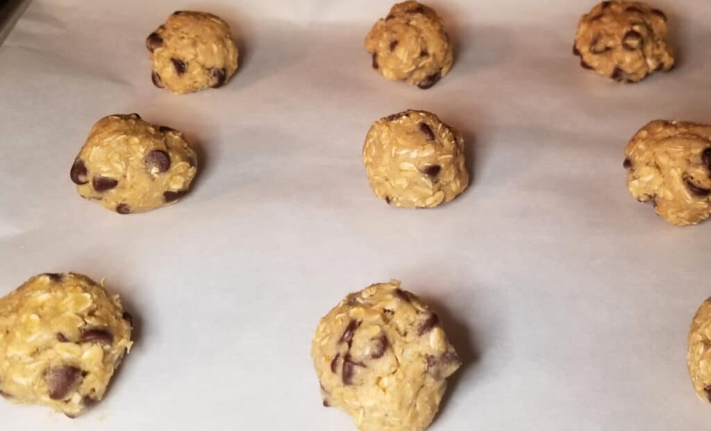 Unbaked cookie dough on a baking sheet with parchment paper