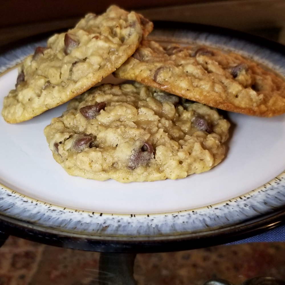 three oatmeal chocolate chip cookies stacked on a plate