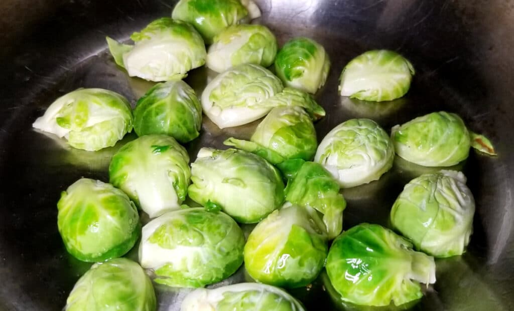 brussels sprouts cooking in a pan on the stove. 
