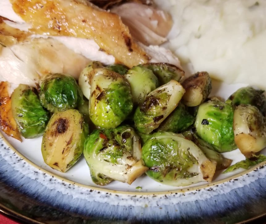 brussels sprouts on a plate with roasted chicken and mashed potatoes