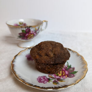 cinnamon sugar banana bread muffin on a floral plate with a matching tea cup.