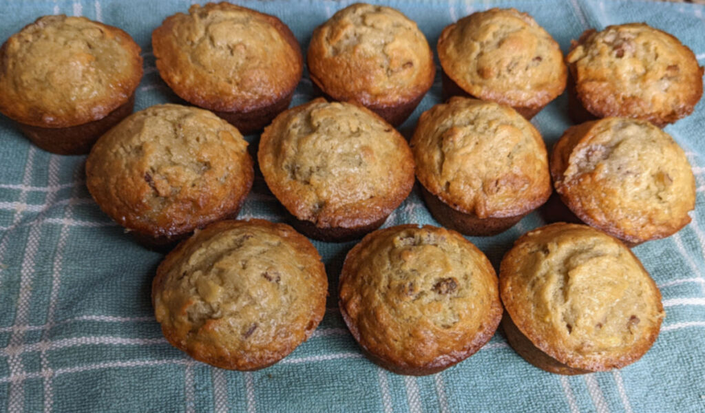 Banana bread muffins cooling on a towel.