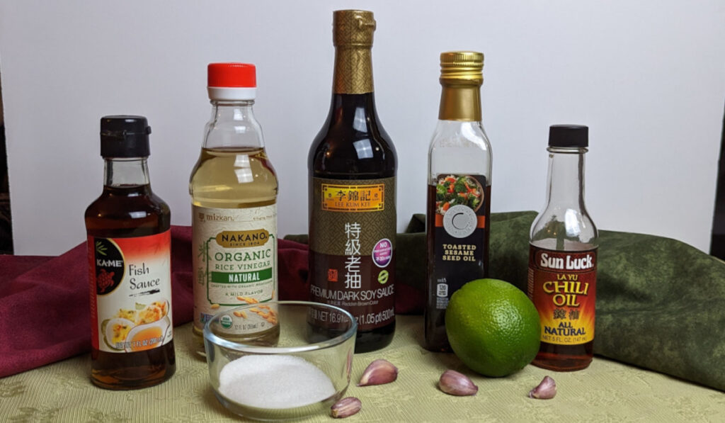 Sauce ingredients from left to right: fish sauce, rice vinegar, sugar, dark soy sauce, garlic, lime, sesame oil, chili oil