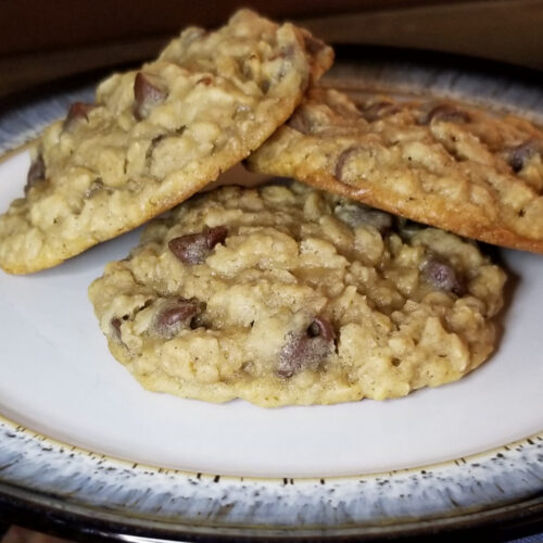 three oatmeal chocolate chip cookies stacked on a plate