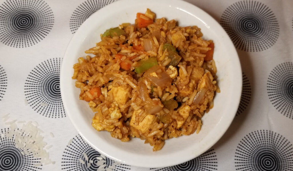 Fried rice in a bowl on a decorative white and blue background. 