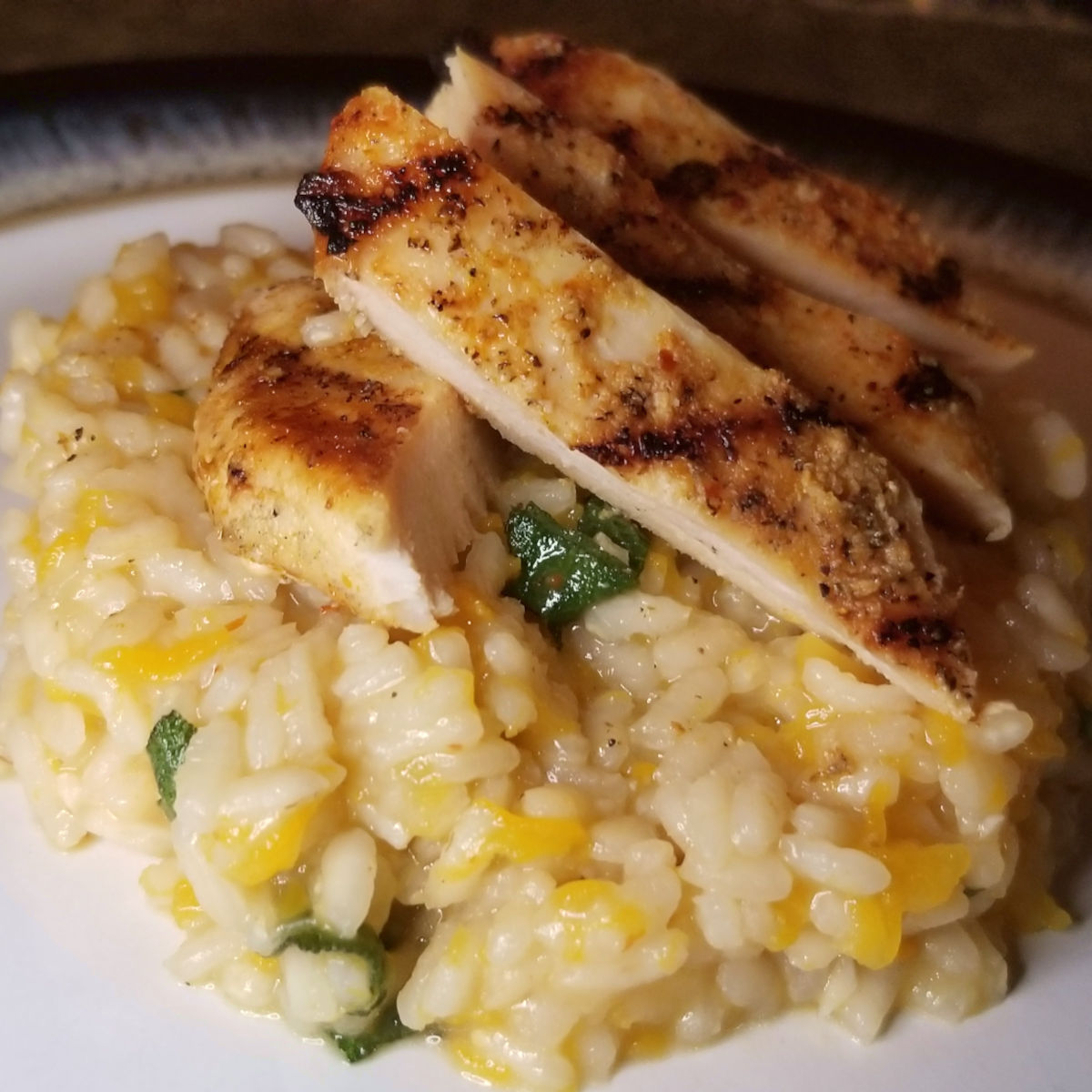 Sliced chicken served over butternut squash risotto.