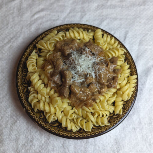 Beef stroganoff served over buttered noodles with shredded parmesan.